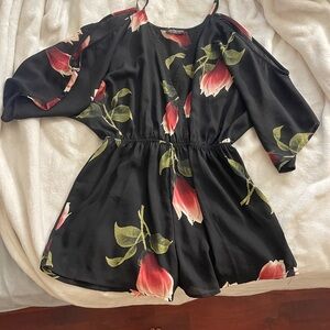 Black and pink romper with a floral design from Fashion Nova